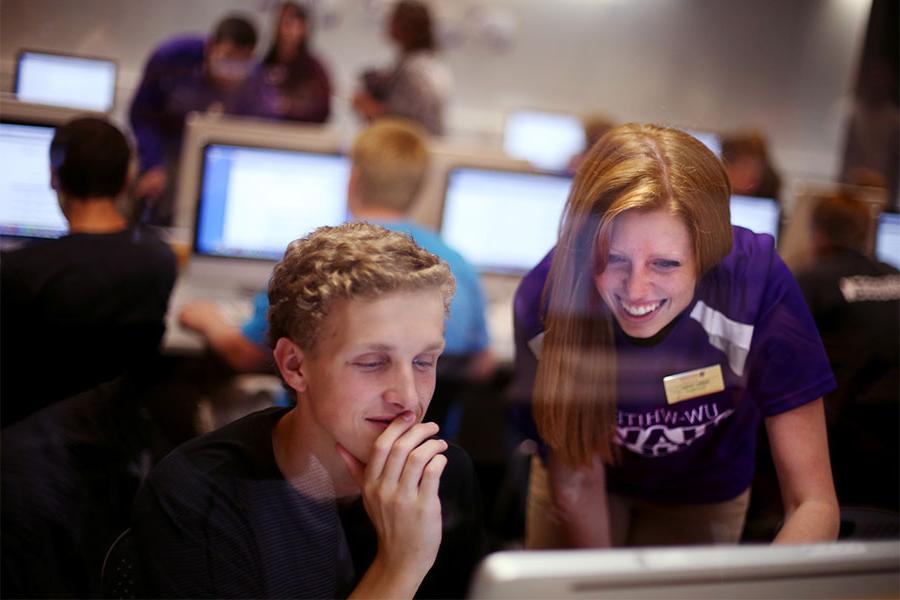  在皇冠365的校园里，学生们一起在电脑上工作.